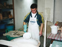 Italian potter dipping bisque into liquid glaze